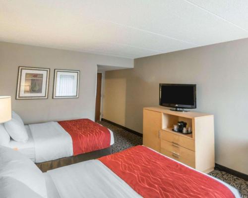 a hotel room with two beds and a flat screen tv at Comfort Inn - NYS Fairgrounds in Syracuse