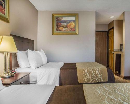 Habitación de hotel con 2 camas y mesa con lámpara en Quality Inn Lockport en Lockport