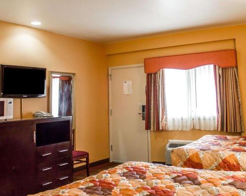 a hotel room with two beds and a flat screen tv at Rodeway Inn MacArthur Airport in Ronkonkoma