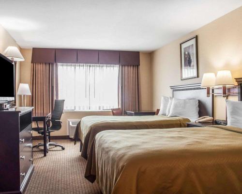 um quarto de hotel com duas camas e uma secretária em Econo Lodge Elmira-Corning em Elmira
