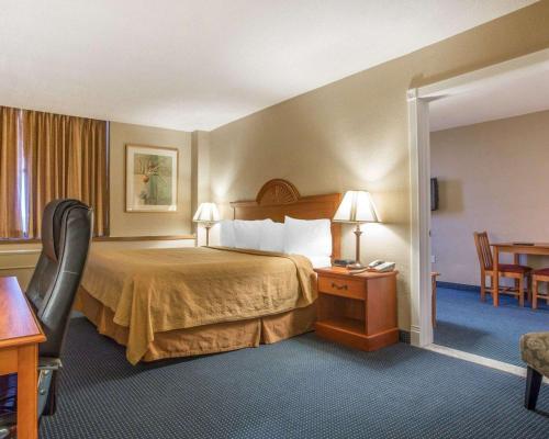 um quarto de hotel com uma cama, uma mesa e cadeiras em Quality Inn Massena em Massena