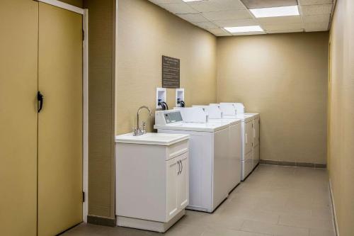 a laundry room with white washers and dryers at Comfort Inn Medford-Long Island in Medford
