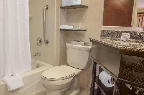 a bathroom with a toilet and a sink and a tub at Comfort Inn & Suites LaGuardia Airport in Queens