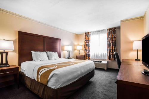 una camera d'albergo con un grande letto e una scrivania di Quality Inn University Area a Cortland