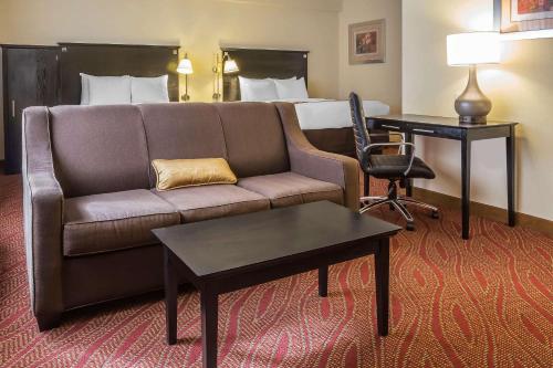 a living room with a couch and a bed at Comfort Inn & Suites LaGuardia Airport in Queens