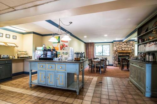 une cuisine avec des armoires bleues et une salle à manger dans l'établissement Quality Inn Cortland - University Area, à Cortland