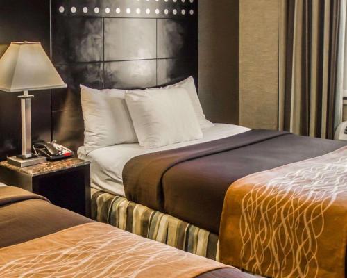 a hotel room with two beds and a lamp at Rodeway Inn Bronx Zoo in Bronx