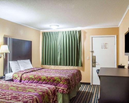 a hotel room with two beds and a window at Amherst Inn & Suites in Amherst