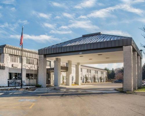 a large building with a flag in front of it at Clarion Pointe Jamestown - Falconer in Jamestown