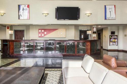 a lobby with a couch and a flat screen tv at Clarion Hotel and Conference Center in Ronkonkoma