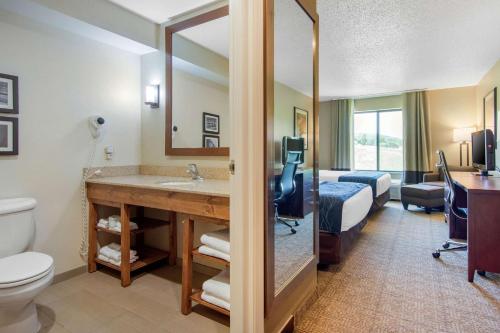 Habitación de hotel con baño con cama y lavamanos en Comfort Inn & Suites Milford - Cooperstown, en Cooperstown