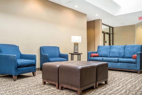 a waiting room with blue chairs and a ottoman at Comfort Inn The Pointe in Niagara Falls