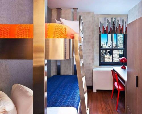 a room with a bed, a chair, and a window at The Paul Hotel NYC-Chelsea, Ascend Hotel Collection in New York