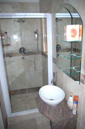 a bathroom with a sink and a glass shower at Bon A Vie Self-catering and b&b Gonubie Full Solar Power, no load shedding! in Gonubie