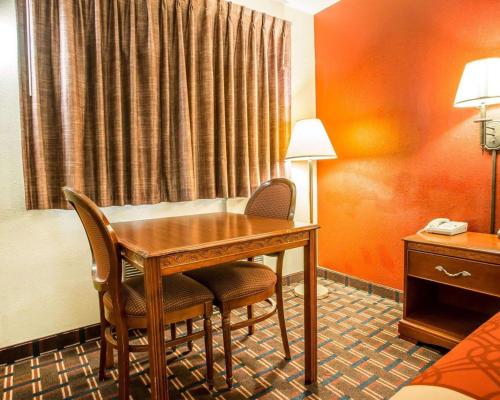 a hotel room with a desk and chairs in a room at Rodeway Inn in Montpelier