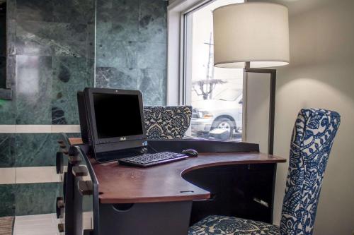 a desk with a laptop computer and a chair at Comfort Inn Sandusky in Sandusky