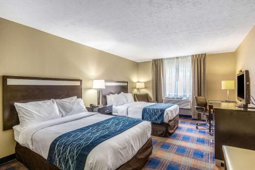 a hotel room with two beds and a television at Comfort Inn Independence in Independence