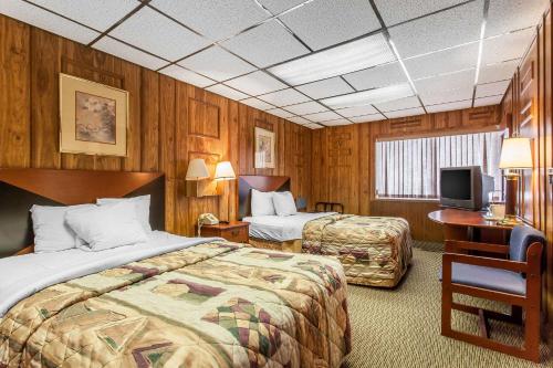 a hotel room with two beds and a television at Rodeway Inn Sandusky North in Sandusky