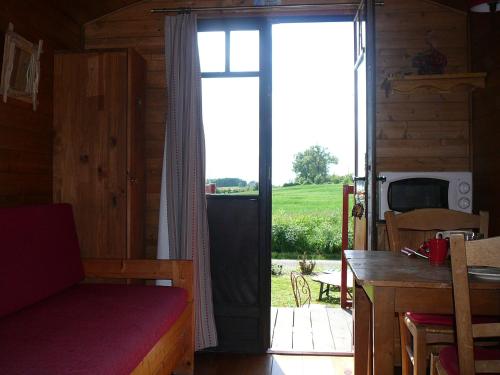 a room with a door open to a patio with a table at Les Chalets des Mousquetaires in Mirepoix