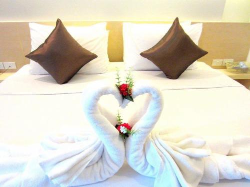 two swans made to look like hearts on a bed at Khuang Singh Residence & Hotel Chiangmai in Chiang Mai
