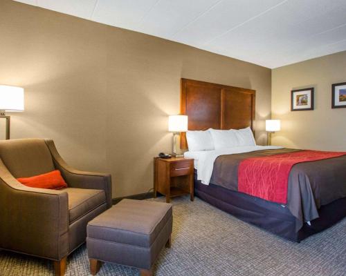 Habitación de hotel con cama y silla en Comfort Inn Dayton - Huber Heights, en Huber Heights