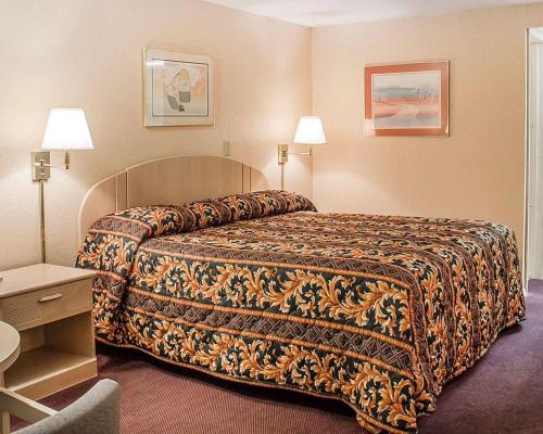 a hotel room with a bed and two lamps at Rodeway Inn Findlay in Findlay