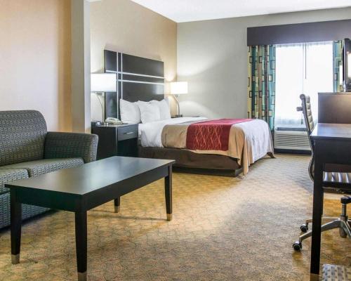 モーミーにあるComfort Inn & Suites Maumee - Toledo I80-90のベッド、ソファ、テーブルが備わるホテルルームです。