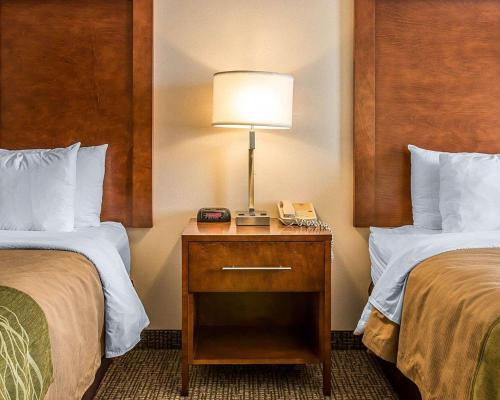 a hotel room with two beds and a lamp on a night stand at Bluffton Inn & Suites in Bluffton