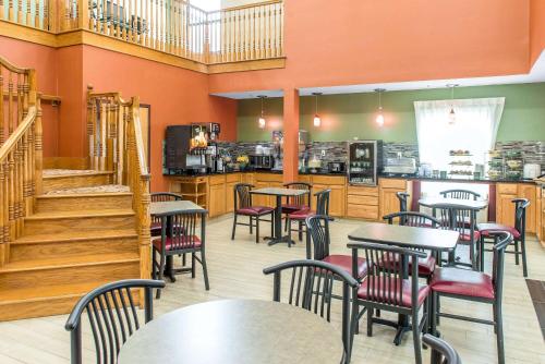 a restaurant with tables and chairs and a staircase at Quality Inn & Suites Columbus West - Hilliard in Columbus