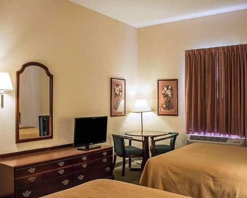 Habitación de hotel con cama y escritorio con TV. en Quality Inn & Suites Bellville - Mansfield, en Bellville