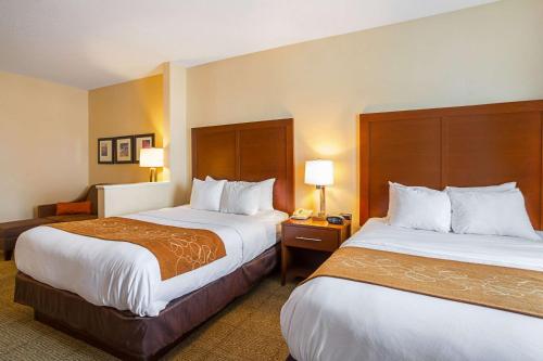a hotel room with two beds and a chair at Comfort Suites in Twinsburg