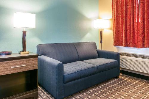 a living room with a blue couch in a hotel room at Quality Inn in Findlay