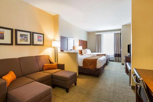 a hotel room with a bed and a couch at Comfort Suites in Twinsburg