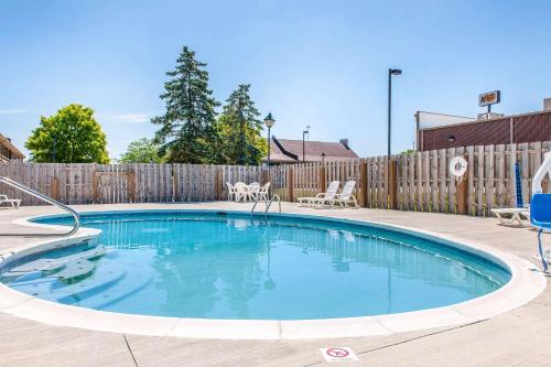 a swimming pool in a backyard with a wooden fence at Quality Inn in Findlay