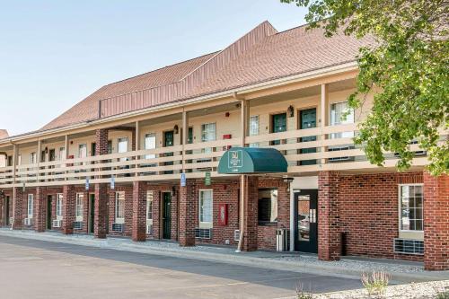 a large red brick building with a green awning at Quality Inn in Findlay