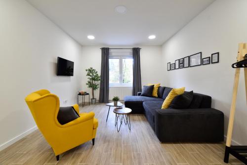 a living room with a couch and a yellow chair at Fishnjak Apartments - Central Zagreb in Zagreb