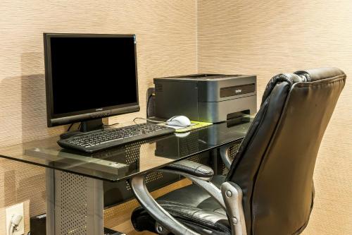a desk with a computer and a monitor and a chair at Comfort Inn in Pickerington