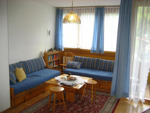 a living room with a blue couch and a table at Appartements Central in Bad Kleinkirchheim