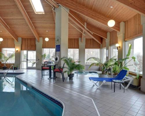 una piscina en un edificio con sillas y mesa en Comfort Inn en Concord