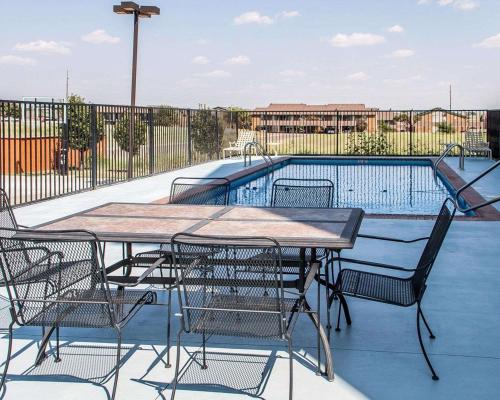 a table and chairs next to a swimming pool at Comfort Inn & Suites in Elk City