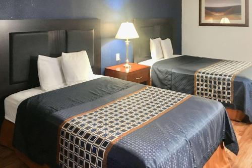 een hotelkamer met 2 bedden en een lamp bij Rodeway Inn in Circleville