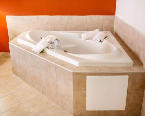 a bathroom with a bath tub with towels in it at Sleep Inn & Suites Oklahoma City Northwest in Oklahoma City