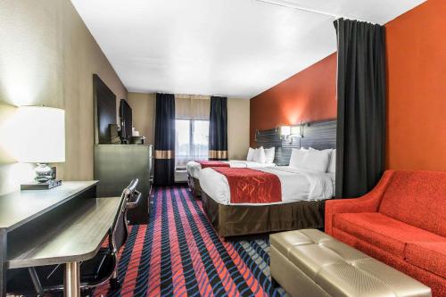 a hotel room with a bed and a red chair at Comfort Suites Fairgrounds West in Oklahoma City
