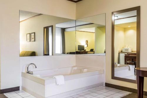a bathroom with a tub and a large mirror at Comfort Inn & Suites Ardmore in Ardmore