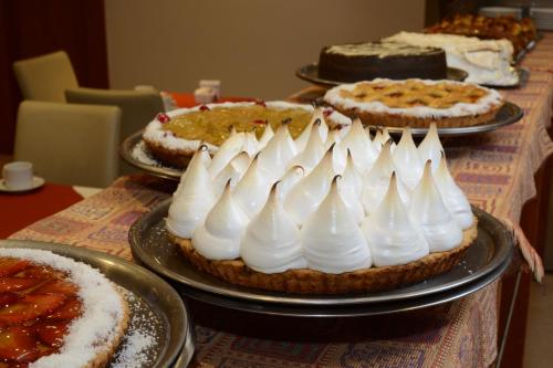 a table topped with three pies with white frosting at Gran Hotel Skorpios in Mar del Plata