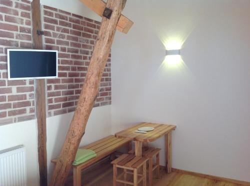 Neuburg-SteinhausenにあるGästehaus Landgut Lischowの木製ベンチと壁掛けテレビ付きの客室です。