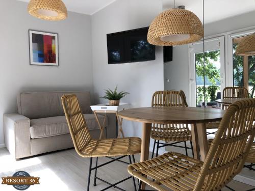salon ze stołem, krzesłami i kanapą w obiekcie Resort 36 w mieście Mikołajki