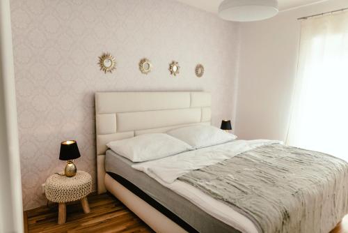 a white bedroom with a bed and a night stand at Luxury Apartments Zelny Trh 4 in Brno