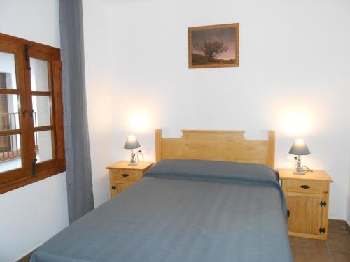 カベズエラデルバレにあるEl Portal Viejoのベッドルーム1室(青いベッド1台、ナイトスタンド2台付)