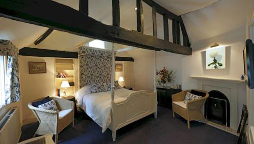 a bedroom with a canopy bed and two chairs at Bath Place Hotel in Oxford